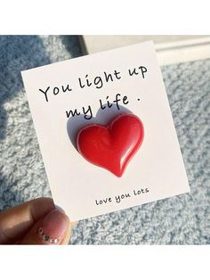 someone holding up a card with a heart on it that says, you light up my life love you later