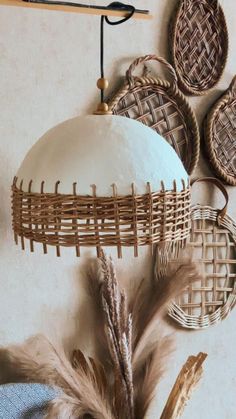 decorative items are hanging on the wall in front of a white ball and some brown feathers