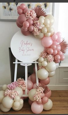 the balloon arch is decorated with pink and white balloons