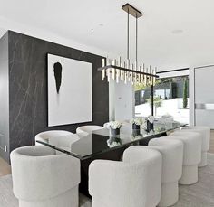 an elegant dining room with white chairs and black walls