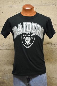 a black oakland football t - shirt with the oakland raiders on it's chest