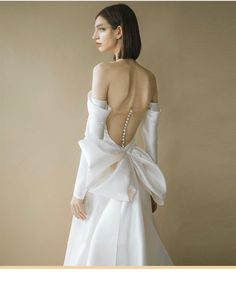 the back of a woman's wedding dress with a bow