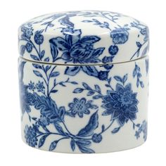 a blue and white container with flowers on it's lid, sitting on a white surface