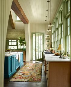 a kitchen area with blue cabinets and an area rug on the floor in front of it