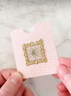 someone is holding up a small card with a flower in it on the inside of it