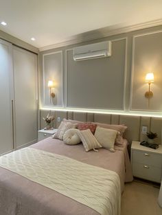 a bedroom with a bed, nightstands and two lamps on either side of the headboard