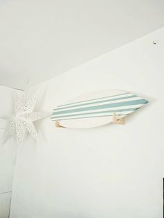 a surfboard mounted to the side of a white wall next to a starfish