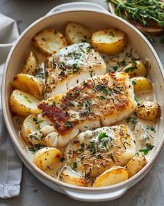 a white bowl filled with chicken and potatoes