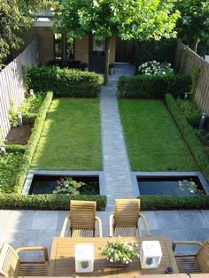 an aerial view of a small backyard garden with table and chairs in the foreground