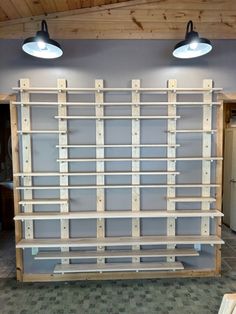 a room with two lamps and shelves made out of wooden pallets on the wall