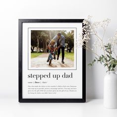 a framed photograph of a man riding a bike with the words stepped up dad on it