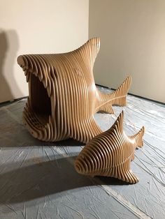 two wooden sculptures sitting on top of a floor