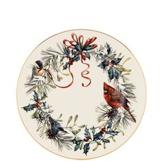 a white plate with a red bird and holly wreath on the rim, which reads s