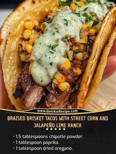 a hand holding a taco filled with meat and corn next to other food items