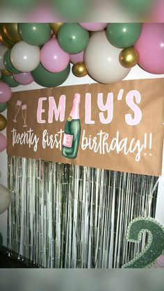 balloons and streamers are hanging from the ceiling in front of a sign that reads,'family's twenty first birthday '