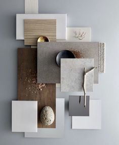 an arrangement of different materials on a gray wall with white and gold accents, including a ball