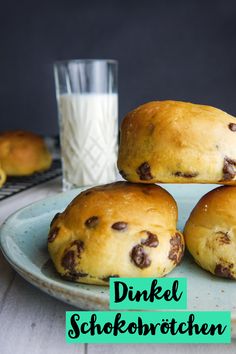 three chocolate chip muffins on a blue plate with a glass of milk in the background