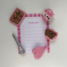 a pink and white checkered paper with donuts on it next to utensils