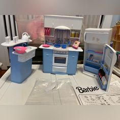 several toy kitchen appliances sitting on top of a white table with plastic bags around them