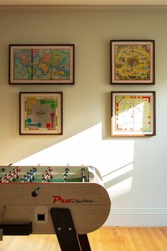 a room with some pictures on the wall and a foo - ball table in front of it