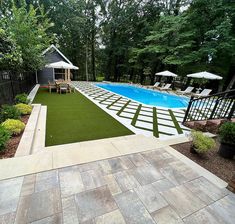 an outdoor swimming pool surrounded by lush green grass