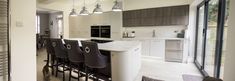 an open kitchen and dining area with bar stools