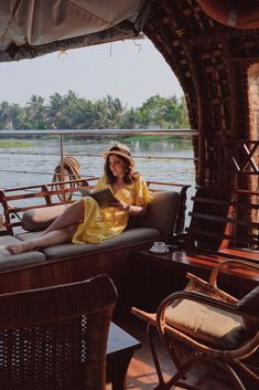 a woman sitting on top of a couch next to a lake