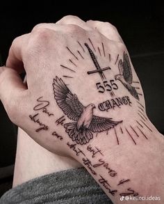 a person with a tattoo on their arm holding a cross and two birds in the air