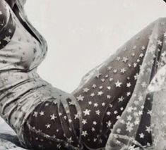 a woman sitting on top of a snow covered ground wearing tights and stars print stockings