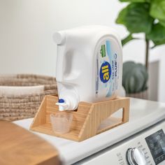 a jug of milk sitting on top of a dryer next to a wooden tray