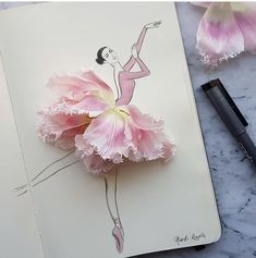 a drawing of a ballerina holding a pink flower on top of a notepad