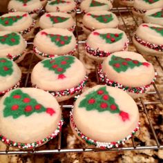 decorated cookies sitting on top of a cooling rack