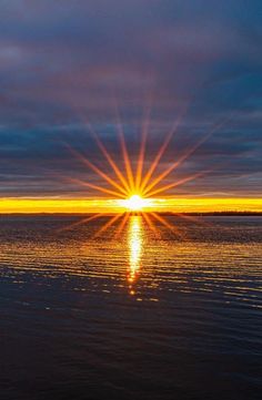 the sun is setting over the water and reflecting it's reflection in the water