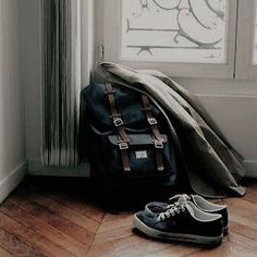 a pair of shoes and a backpack sitting on the floor next to a radiator