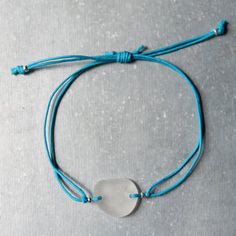 a blue string bracelet with a white heart on it