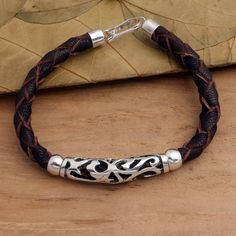 Supple leather in dark brown is braided to create this elegant bracelet for men and women. The bracelet is centered by a brightly polished sterling silver openwork pendant flanked by two silver beads. Fire Spirit, Leather Pendant, Braided Leather Bracelet, Elegant Bracelet, Bracelet For Men, Pendant Bracelet, Braided Leather, Black Enamel, Silver Beads