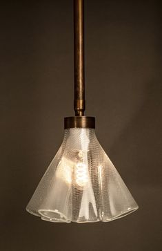 a light that is hanging from a metal pole with a glass cone on it's end