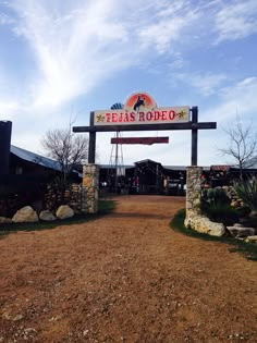 a sign that reads el paso rodeo on the side of a dirt road in front of a building