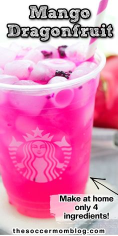 a pink drink in a plastic cup with ice cubes on top and the words mango dragonfruit above it