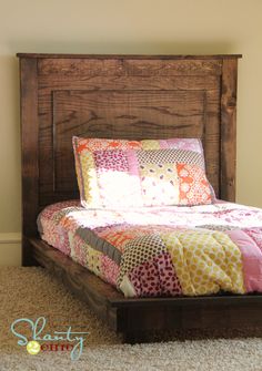 a bed sitting in the middle of a bedroom under a slanted ceiling