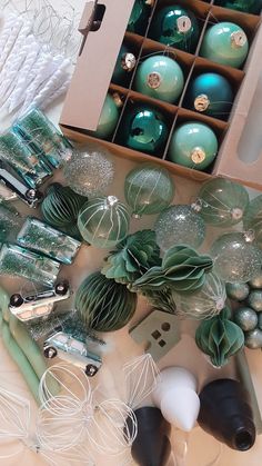 green and white ornaments are sitting in a box next to other christmas ornament