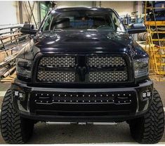 the front end of a black truck parked in a garage