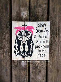 a wooden sign that says she's beauty and grace she will peck you in the face