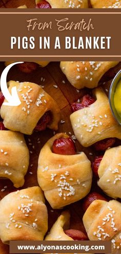 pigs in a blanket with mustard and sesame seeds on top, next to a bowl of dipping sauce