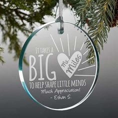 a glass ornament hanging from a tree with the words, it takes a big heart to help shape little minds much appreciation