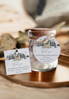 a glass jar filled with marshmallows sitting on top of a wooden tray