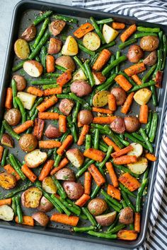 a pan filled with potatoes, green beans and carrots