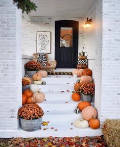 pumpkins and gourds decorate the front porch for fall