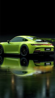 a lime green sports car is reflected in the wet surface with its hood down and it's lights on