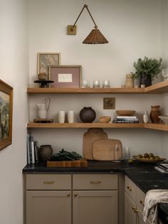 a kitchen with wooden shelves and black counter top next to an open shelf on the wall